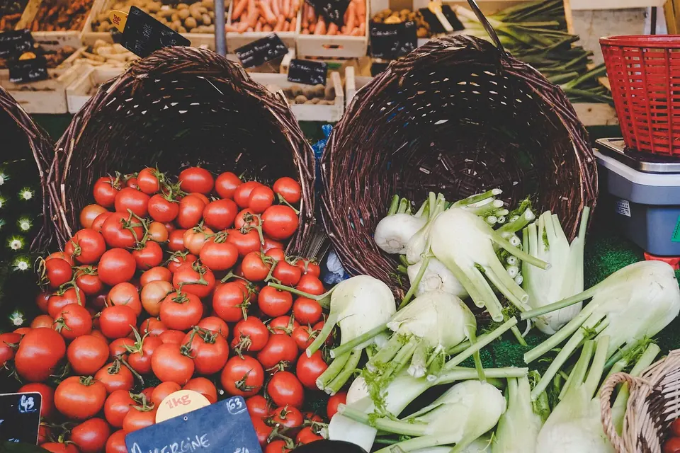 Étal de marché avec des paniers de tomates rouges et de fenouils frais